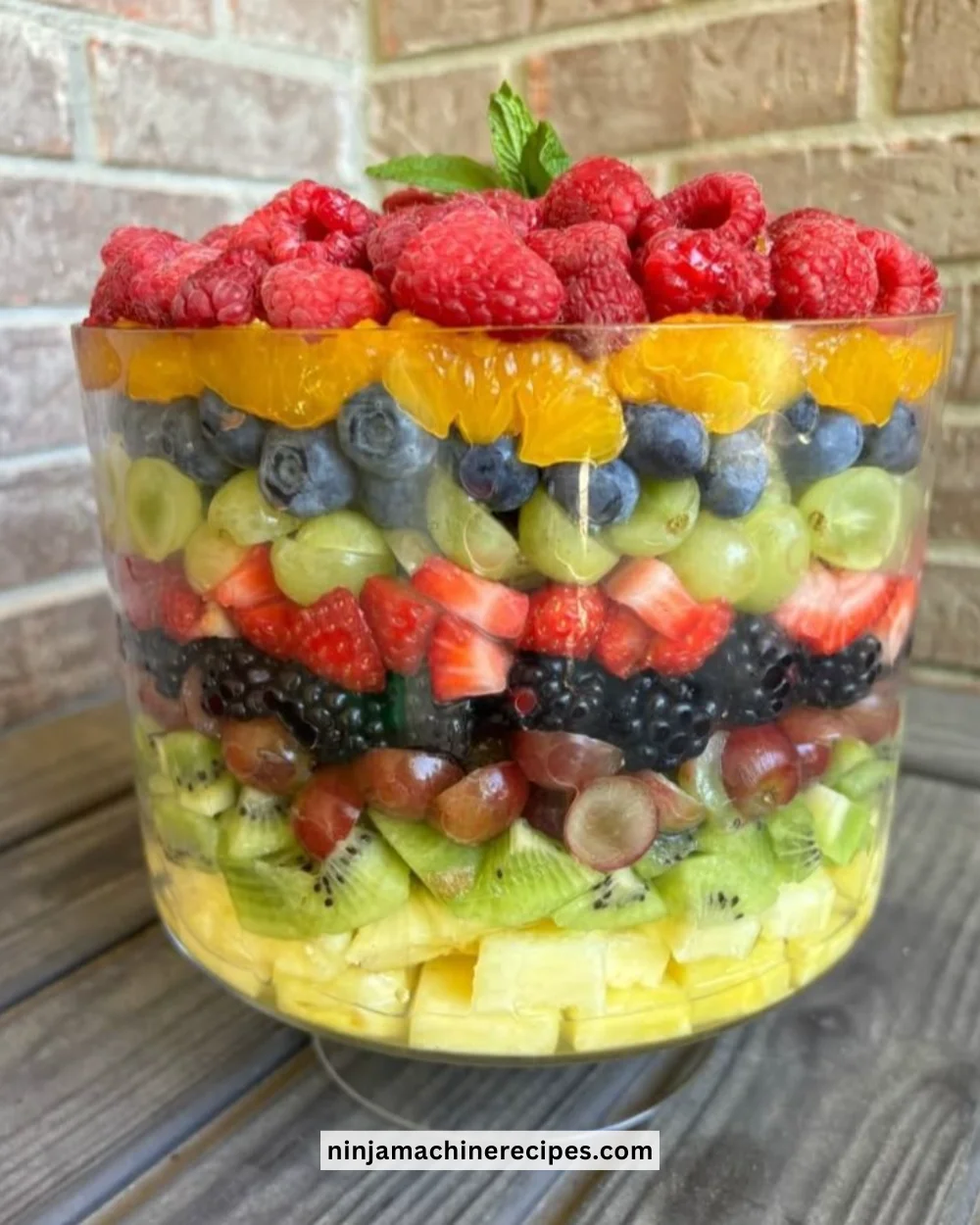 Layered fruit salad with vibrant citrus dressing and fresh fruits
