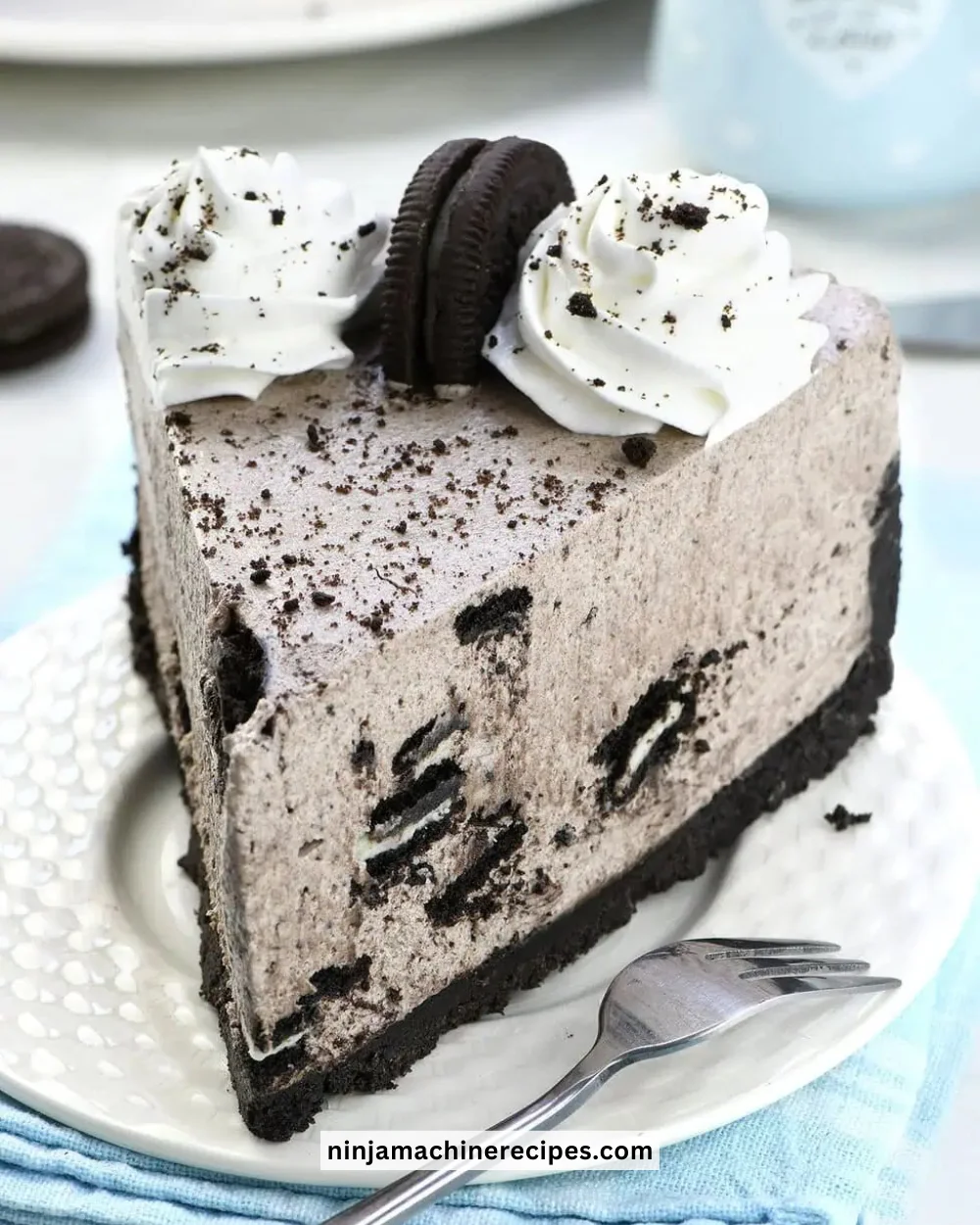 No Bake Oreo Cheesecake topped with crushed Oreos and chocolate drizzle