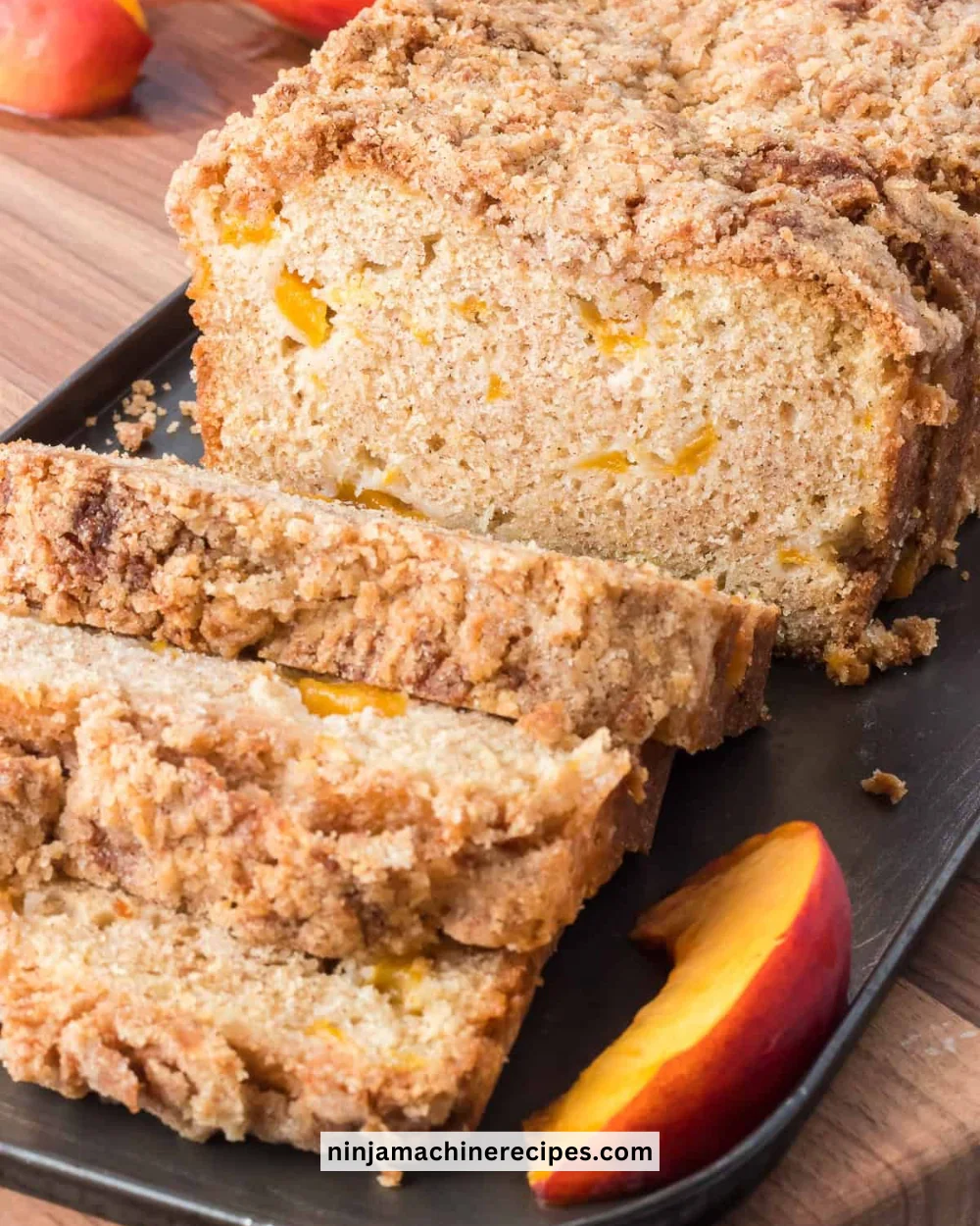 Freshly baked Peach Bread with peaches on a wooden table