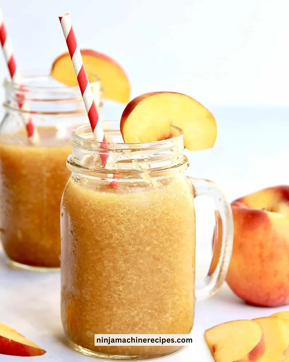 Refreshing homemade Peach Slushie in a glass with ice and fresh peaches