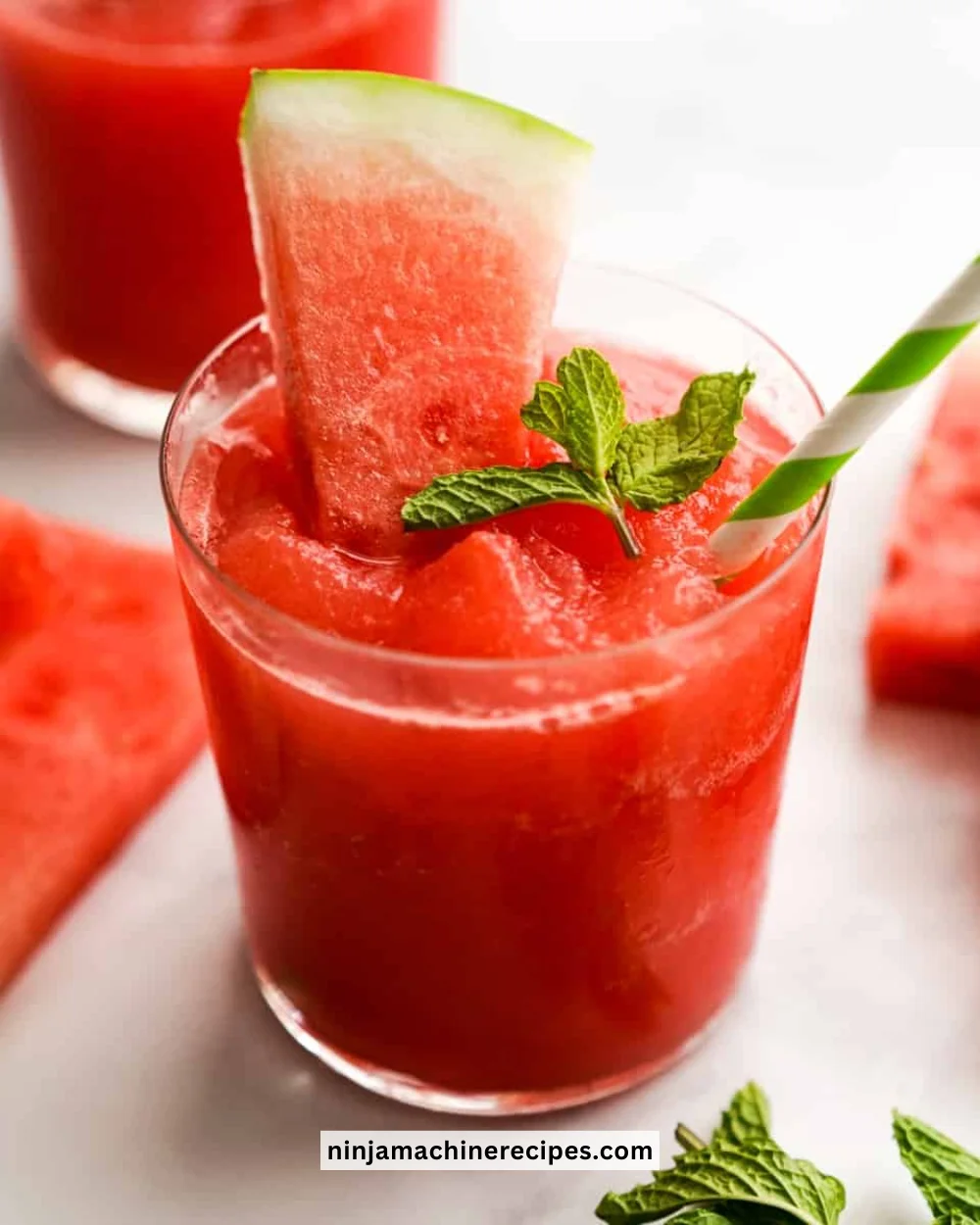 Refreshing watermelon slushie in a glass with ice and mint garnish