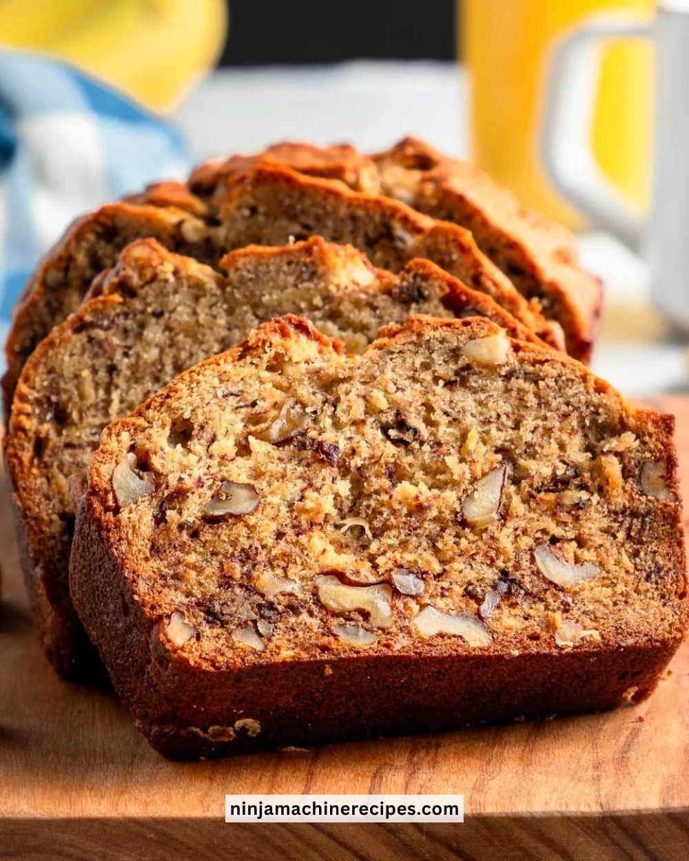 Freshly baked banana nut bread with walnuts and banana slices on a wooden table