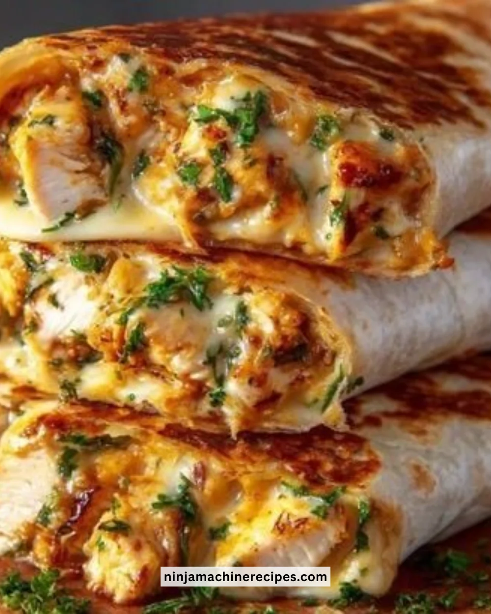 Cheesy garlic chicken wraps served on a plate with fresh ingredients.