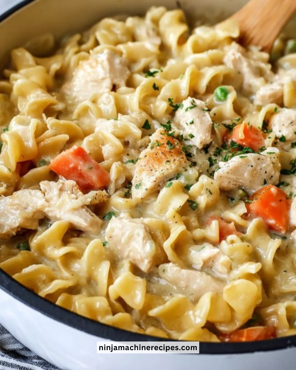 Creamy chicken pot pie pasta served in a bowl garnished with herbs.