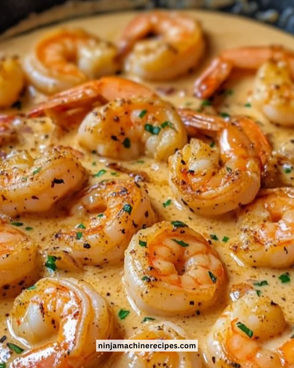 Delicious creamy garlic shrimp served in a bowl garnished with herbs.