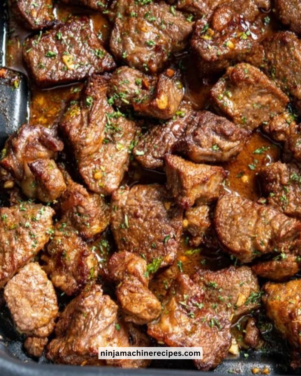 Garlic butter steak bites served with herbs and spices.