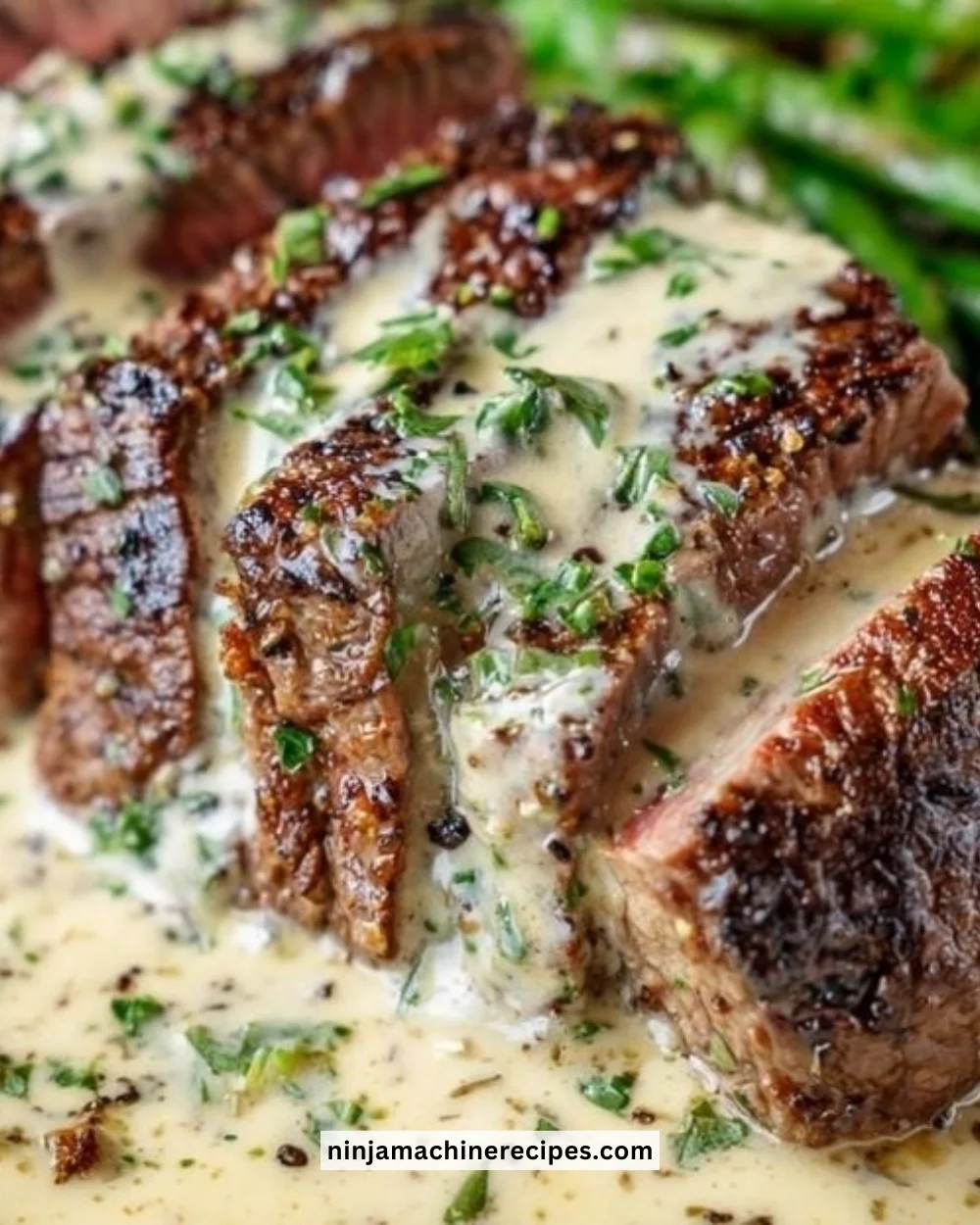 Garlic butter steak topped with rich Parmesan cream sauce on a plate.