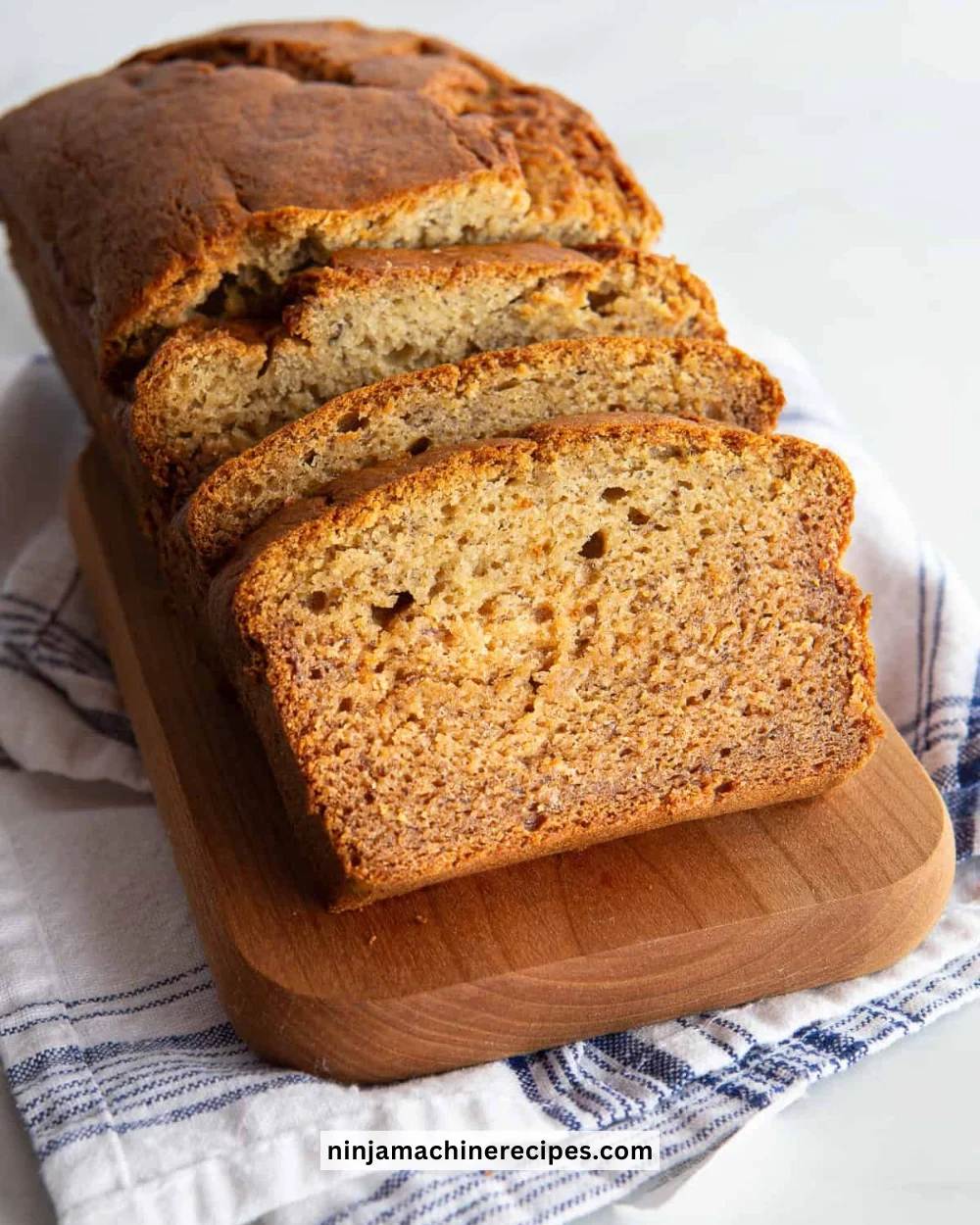 Loaf of gluten-free banana bread with slices on a wooden board