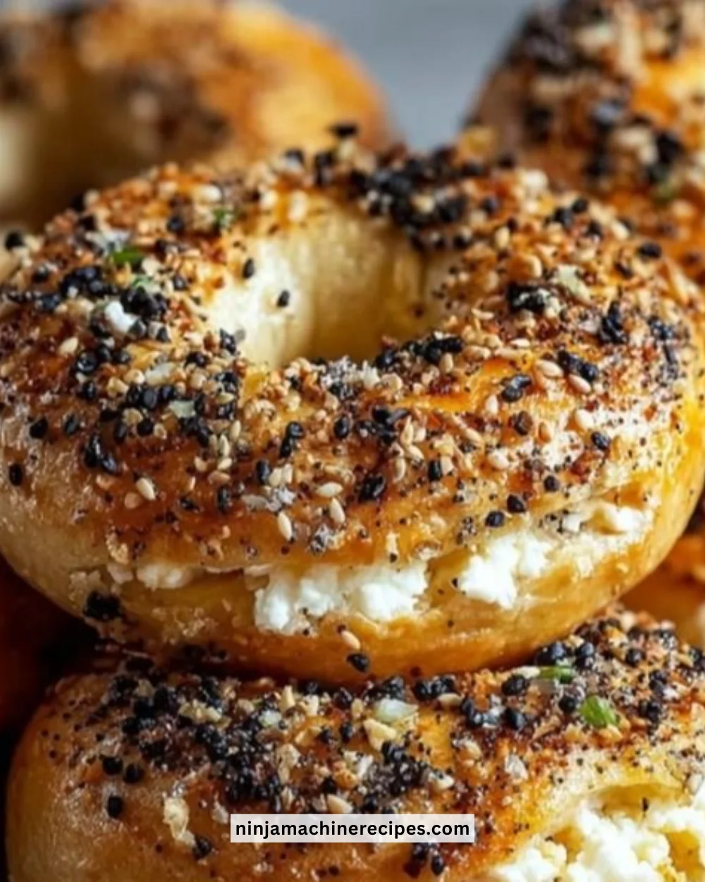 Homemade Greek Yogurt Bagels topped with seeds and served with cream cheese.