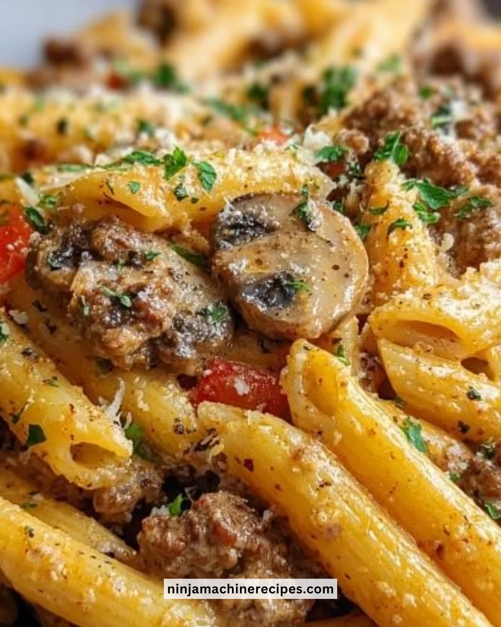Creamy beef pasta dish served in a bowl garnished with herbs