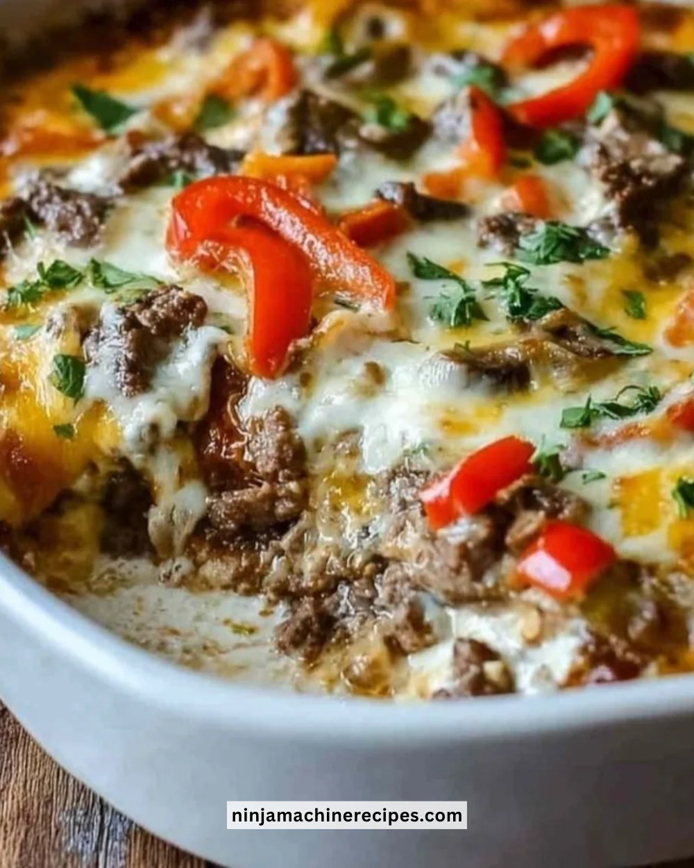 Low Carb Philly Cheesesteak Casserole served on a plate with melted cheese and peppers.