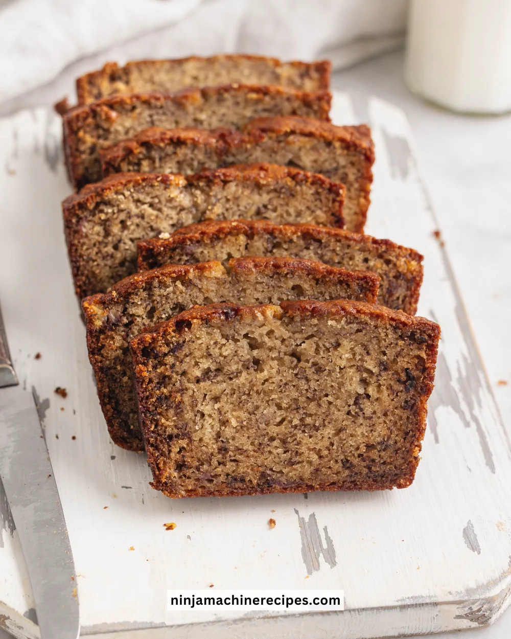 Moist banana bread loaf with bananas and a slice cut out