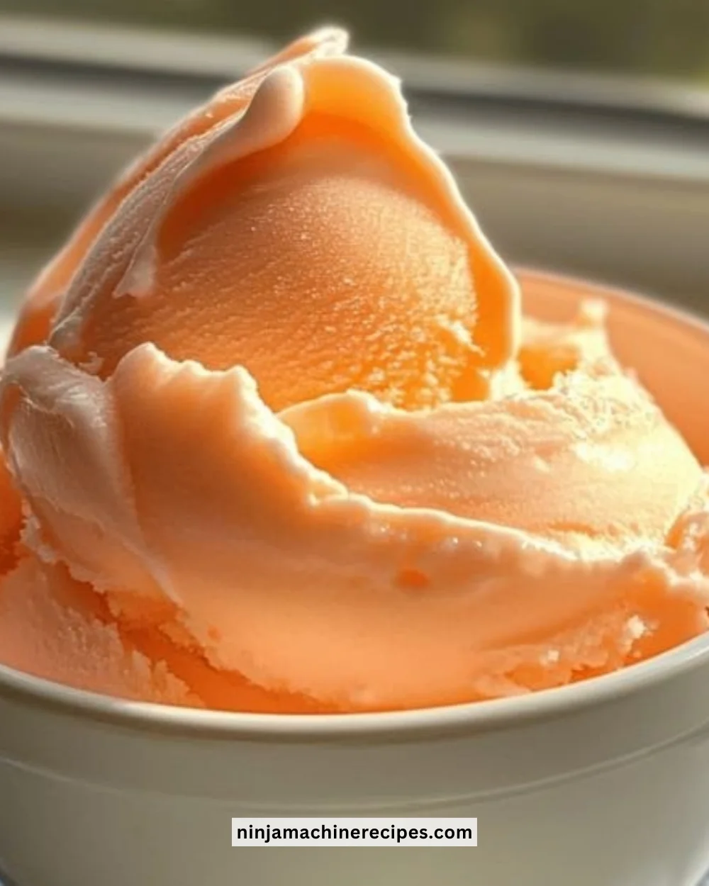 Ninja Creami orange soda ice cream in a bowl topped with orange zest