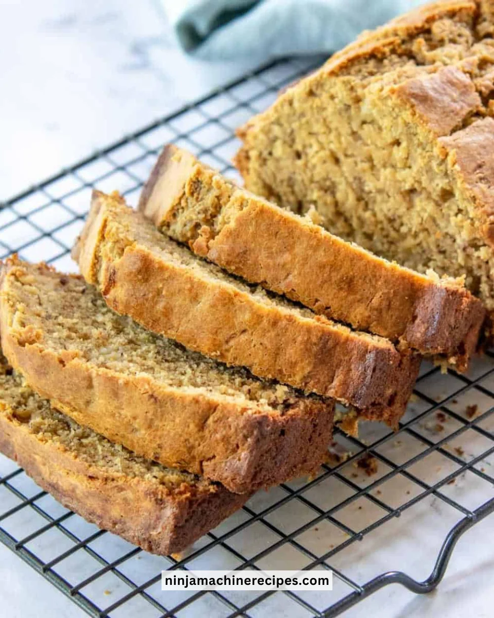 Slice of Simply Healthy Banana Bread on a wooden board with fresh bananas