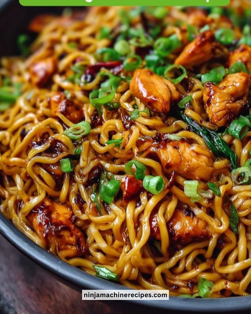 Plate of sticky garlic chicken noodles garnished with green onions