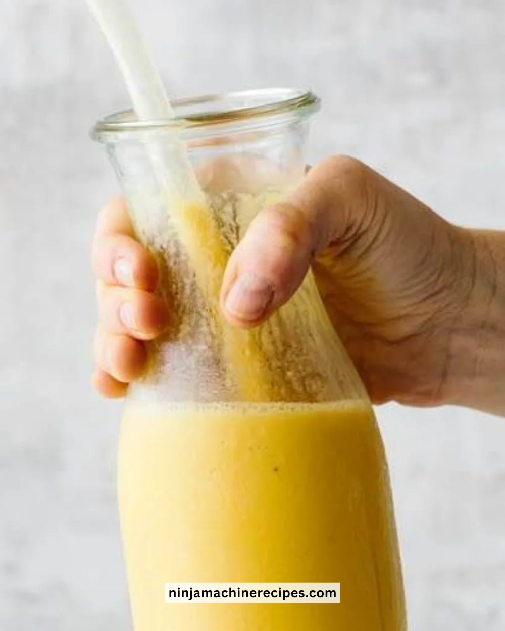 A refreshing turmeric smoothie served in a glass with fresh ingredients.