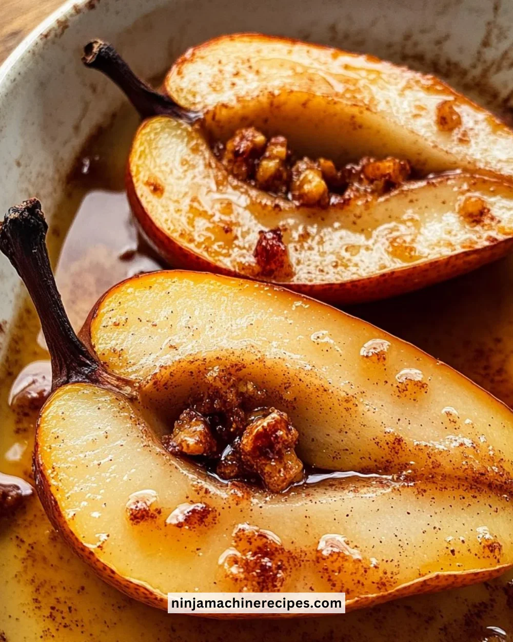 Baked pears drizzled with cinnamon honey on a white plate
