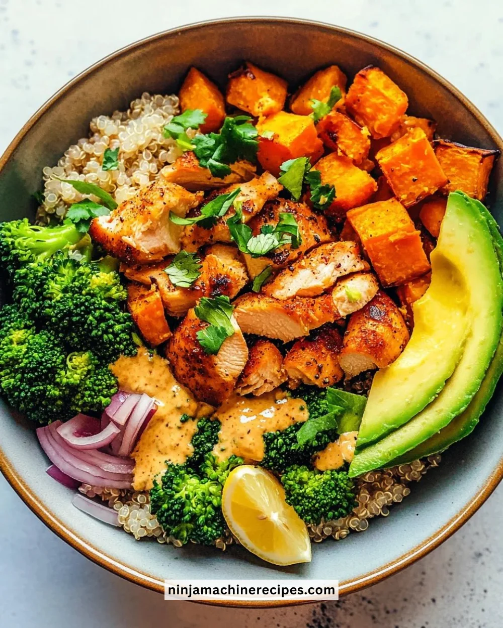 Delicious Chicken & Sweet Potato Buddha Bowl topped with fresh veggies and grains.