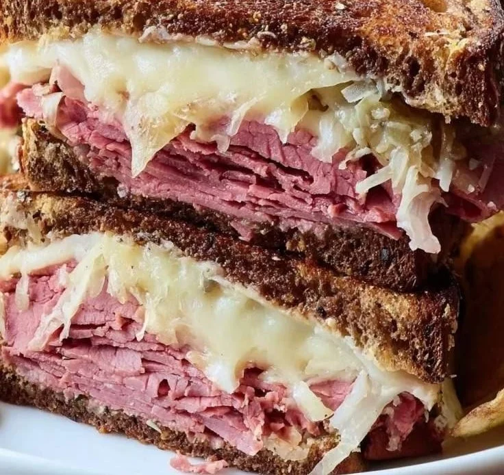 Classic Reuben pastrami sandwich with sauerkraut and melted cheese on rye bread