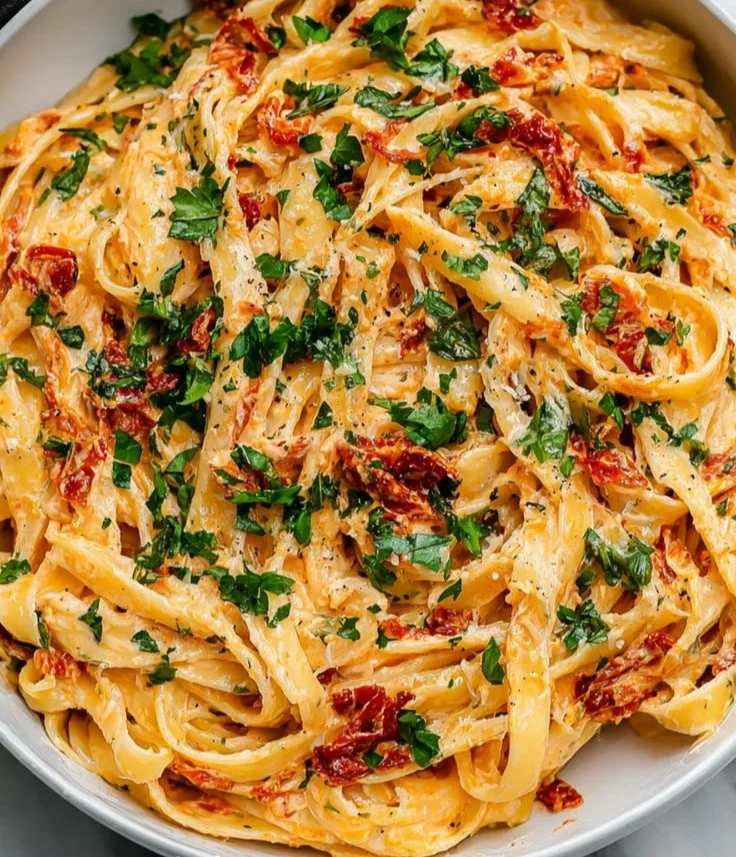 Creamy prawn orzo with sun-dried tomatoes served in a bowl