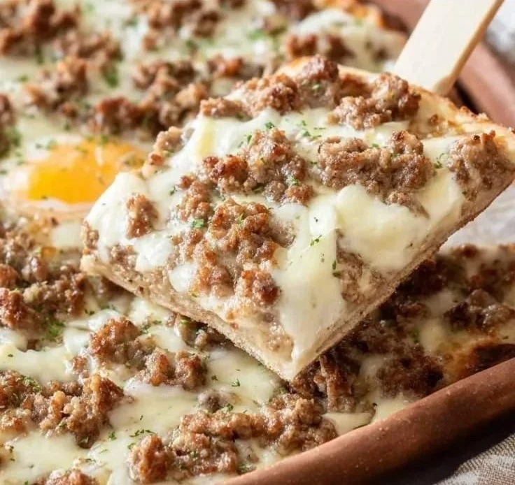 Creamy sausage breakfast pizza with cheese and toppings