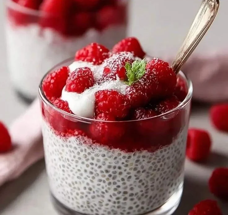 Bowl of creamy vanilla raspberry chia pudding topped with fresh raspberries