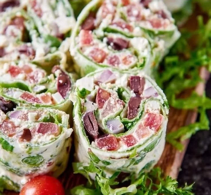 Greek salad pinwheels wrapped with fresh veggies and feta cheese