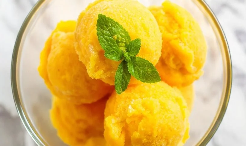 Delicious mango sorbet served in a vibrant bowl with fresh mango slices.