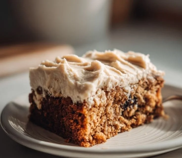 Old-Fashioned Applesauce Cake with frosting and apples on a plate
