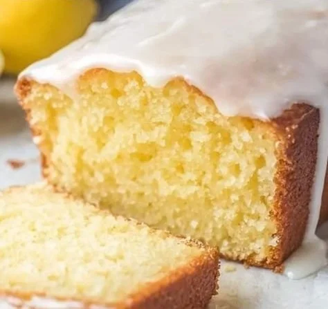 Starbucks Copycat Lemon Loaf slice with lemon glaze on a wooden table