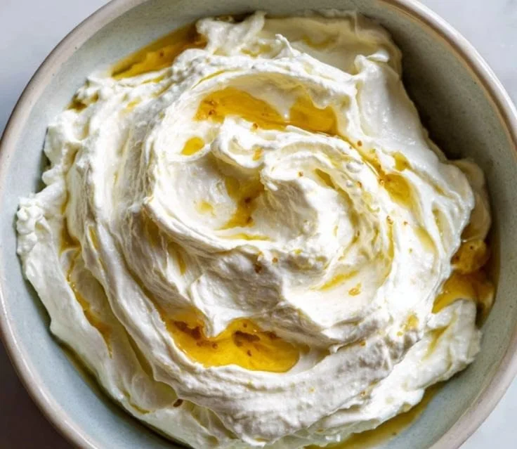 Creamy whipped feta dip served in a bowl with herbs and pita bread