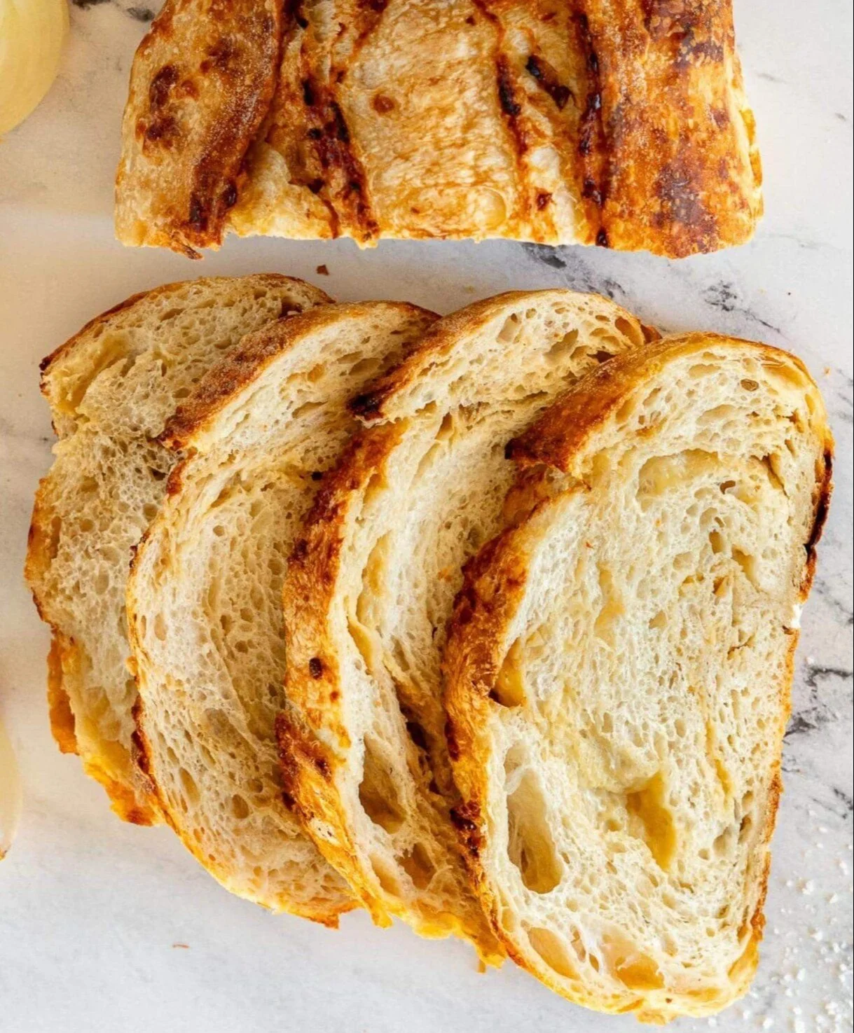 Freshly baked caramelized onion gouda sourdough bread with a golden crust.