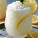 Glass of refreshing Coconut Lemonade with tropical coconut and lemon garnish