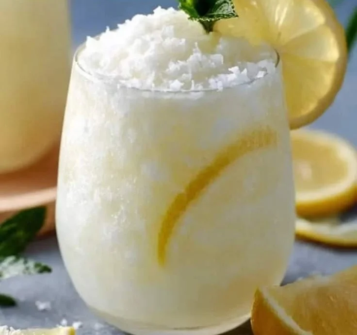 Glass of refreshing Coconut Lemonade with tropical coconut and lemon garnish
