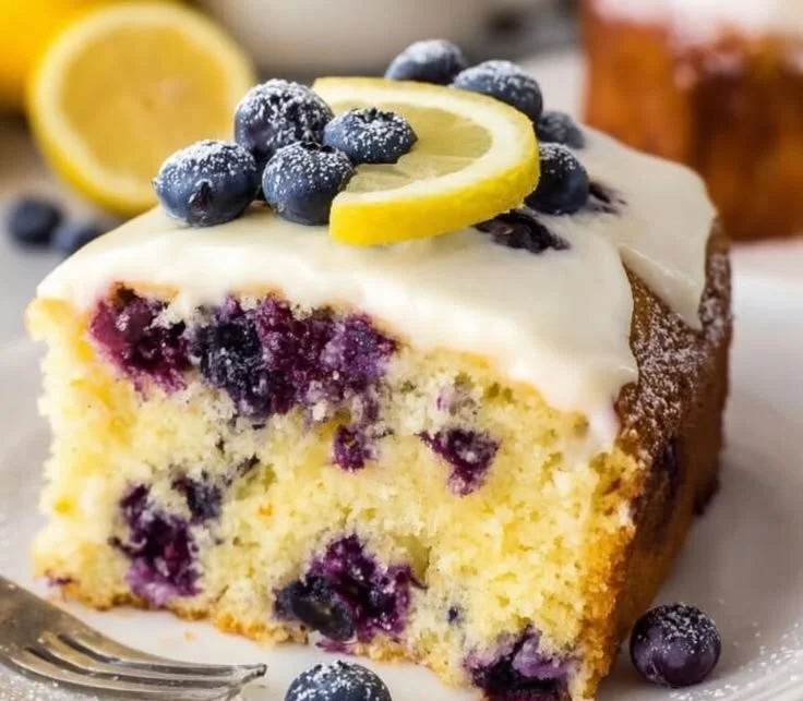 Deliciously moist lemon blueberry cake topped with fresh blueberries and lemon zest.