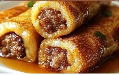 Sausage French Toast Roll-ups served on a plate with syrup