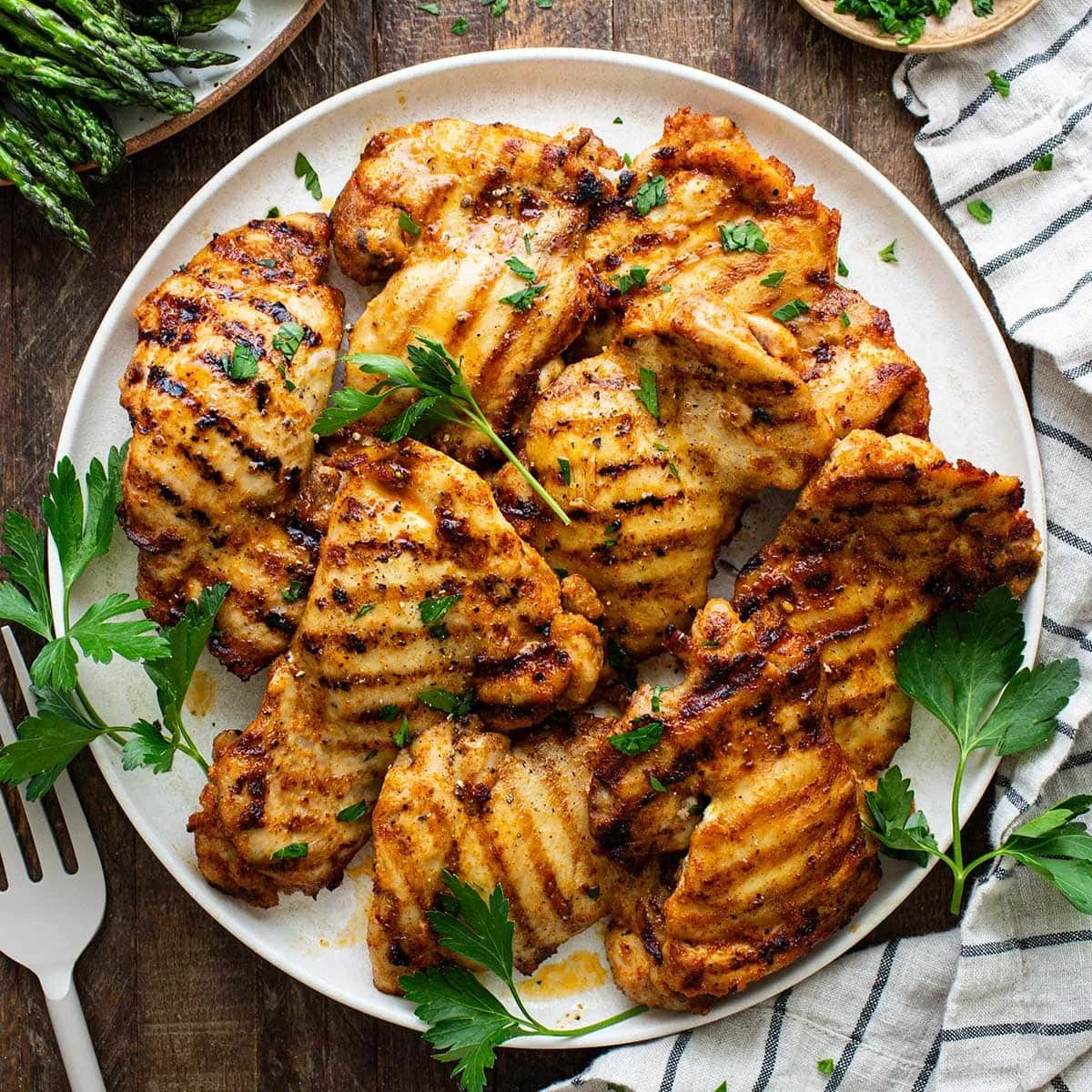 Juicy grilled chicken thighs on the grill with seasoning
