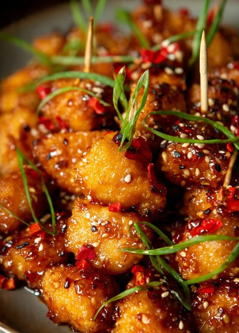 Delicious Sticky Hot Honey Chicken Bites drizzled with sweet, spicy honey glaze.