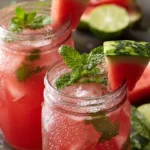 Refreshing watermelon mint drink served in a clear glass with ice and mint leaves