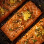 Air fryer leftover salmon topped with garlic butter, showcasing a delicious meal.
