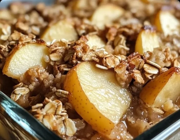 Delicious baked apple oat dish served in a bowl, topped with cinnamon and nuts.