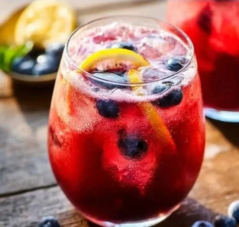 Refreshing blueberry lemonade in a glass garnished with lemon and blueberries.