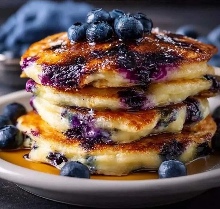 Delicious fluffy blueberry pancakes topped with fresh blueberries and syrup