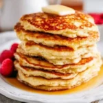 Fluffy cottage cheese pancakes served with syrup and berries