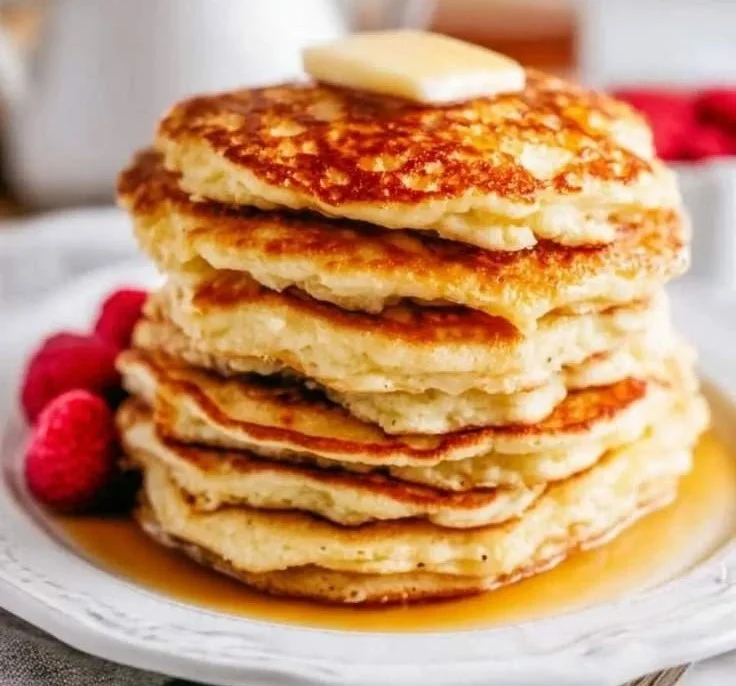 Fluffy cottage cheese pancakes served with syrup and berries