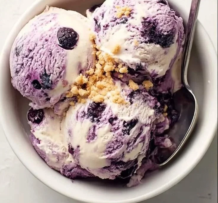 Creamy blueberry cheesecake topped with fresh blueberries and a graham cracker crust.