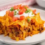 Delicious Doritos Taco Casserole baked in a dish topped with cheese and Doritos