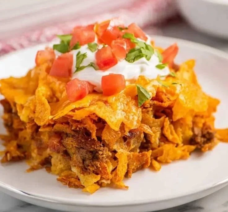 Delicious Doritos Taco Casserole baked in a dish topped with cheese and Doritos