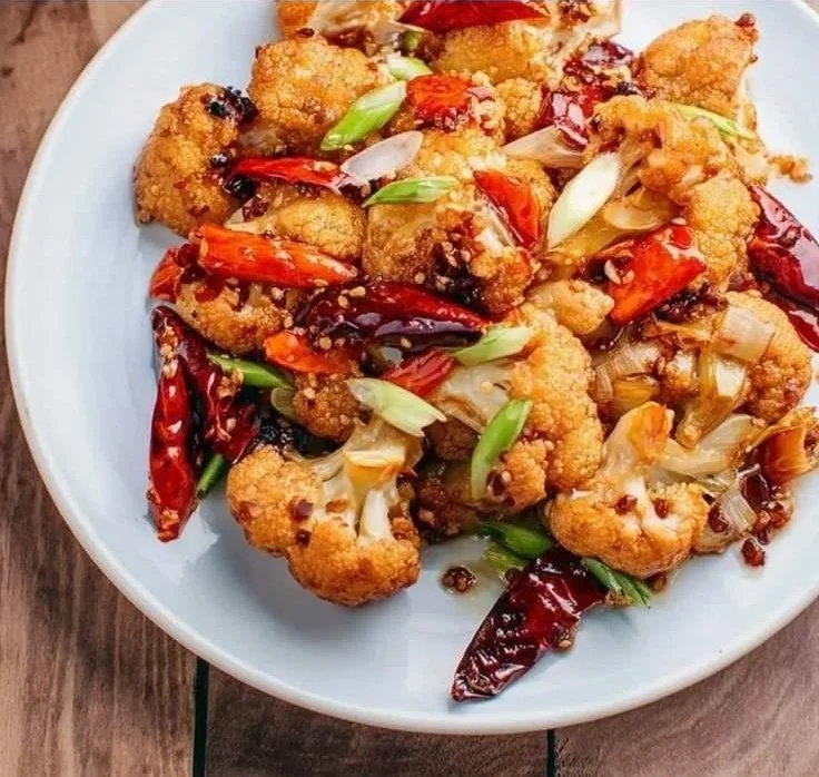 Delicious Kung Pao Cauliflower dish served on a plate with garnishes.