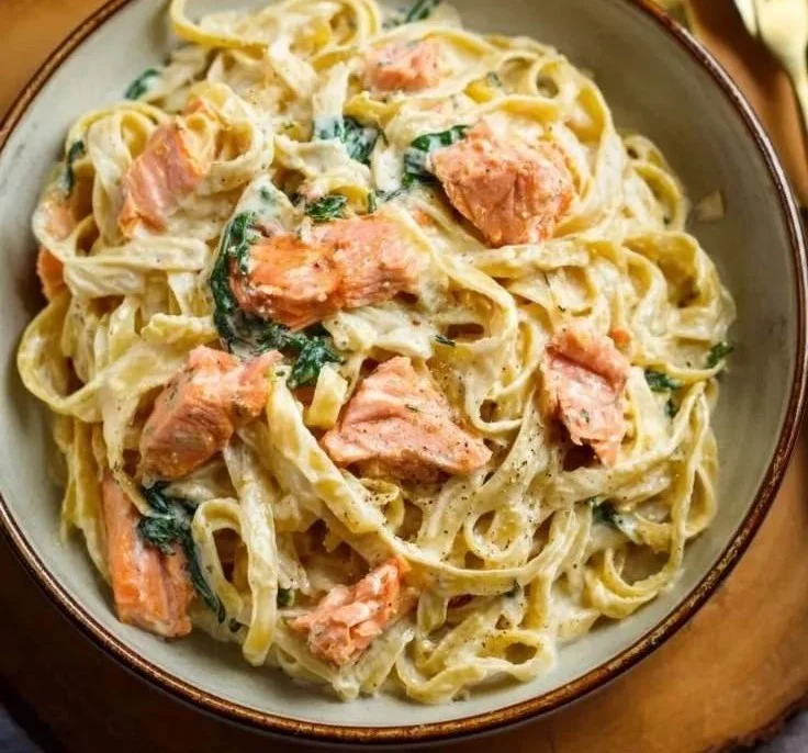 Delicious Salmon Alfredo Fettuccine served on a plate with herbs